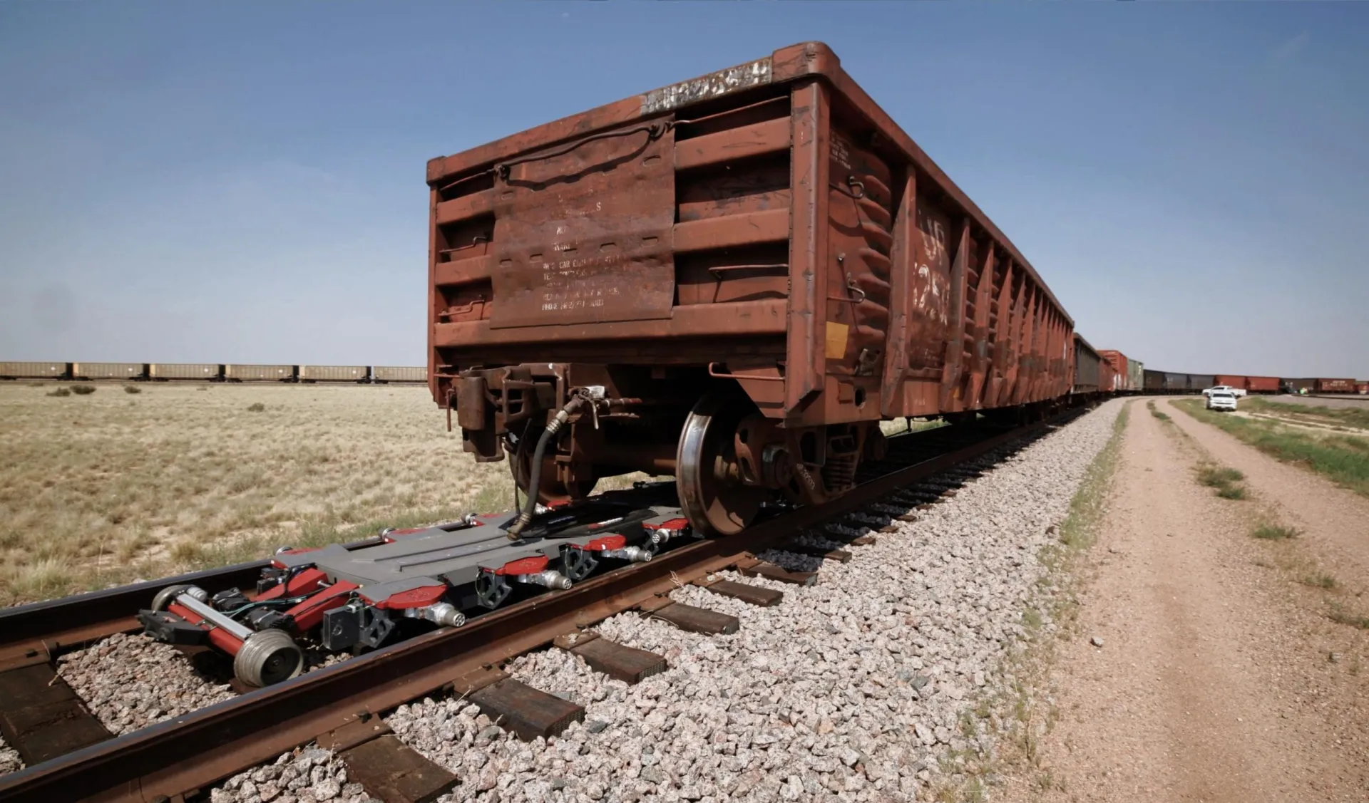 RailGhost autonomous rail vehicle operating beneath a freight railcar